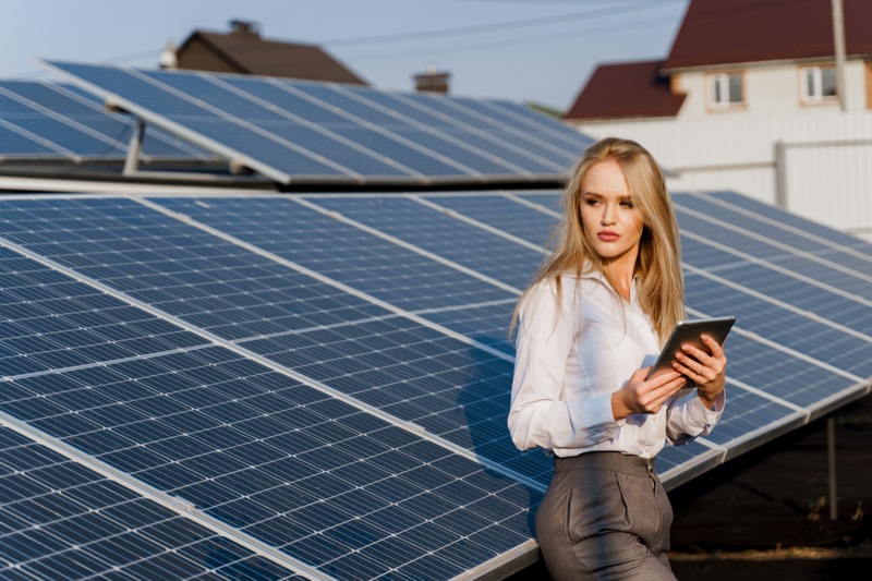 Blonde Woman Solar Panels Holding Tablet Photo