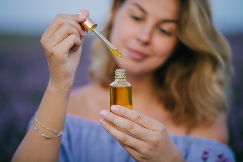 Blurred Woman Holding Oil Bottle
