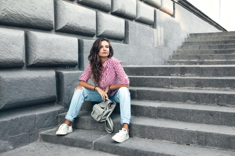 Woman Striped Shirt Jeans White Sneakers Sitting