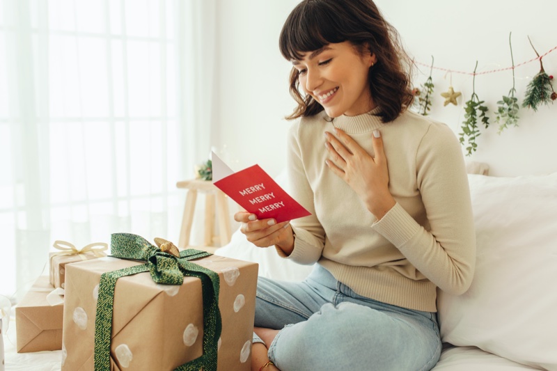 Young Woman Reading Christmas Card Gifts