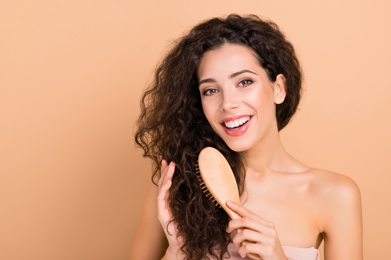 Brunette Woman Brushing Wavy Hair