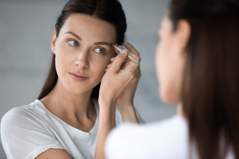 Woman Plucking Eyebrows Tweezer