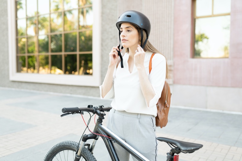 Woman Putting Helmet On Bicycle Chic