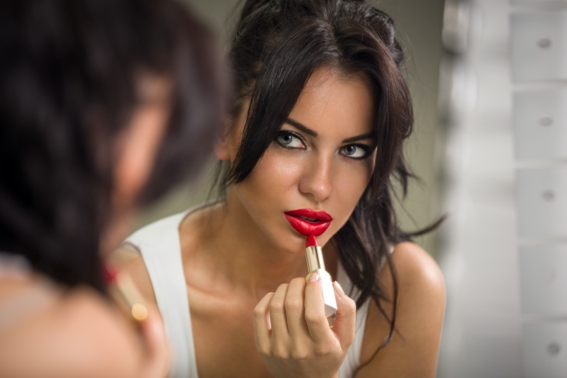 Woman Putting Red Lipstick On