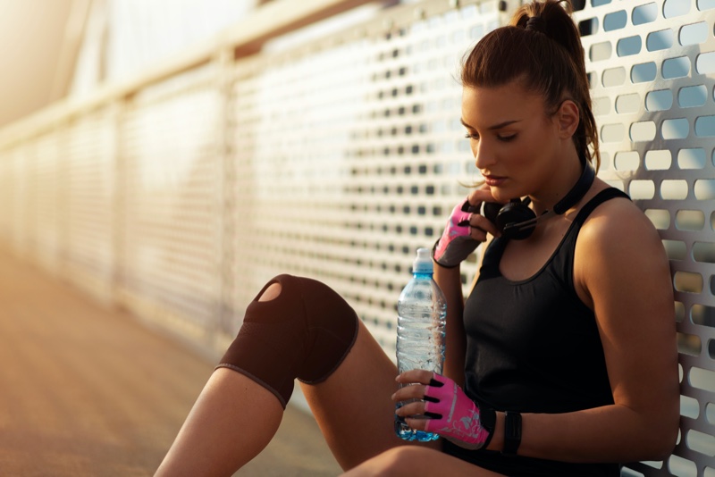 female runner knee sleeve gloves water bottle