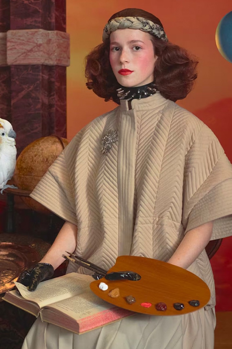 Posing with a book and palette, a model fronts the Gucci Cosmogonie Cruise 2023 campaign.