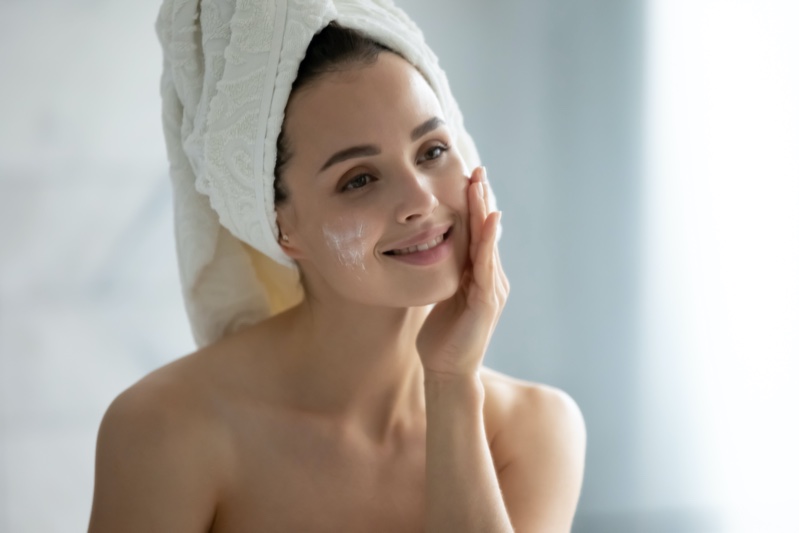 woman applying cream face bathroom skincare
