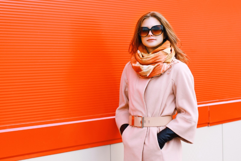 woman belted coat gloves sunglasses scarf