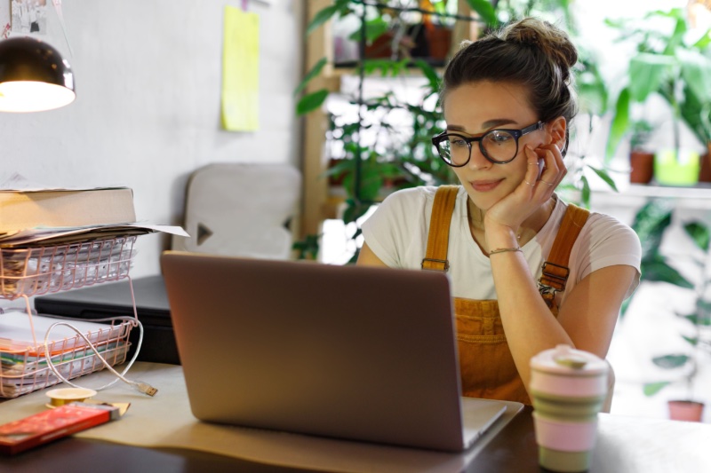 woman laptop glasses overalls