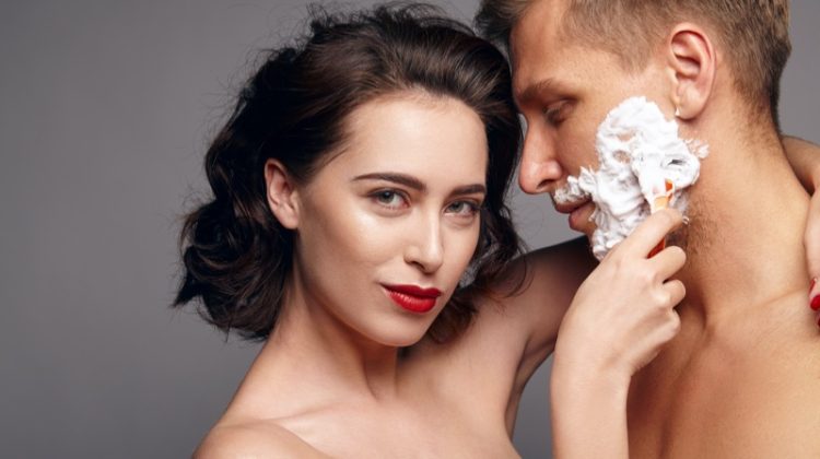 woman shaving mans face beauty