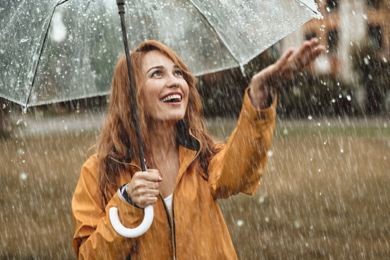 woman smiling rain mustard jacket