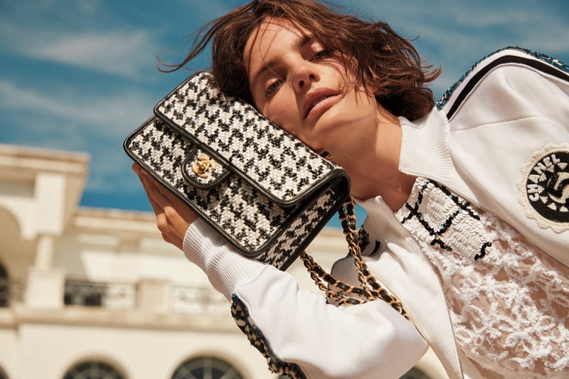 Neiman Marcus x Chanel cruise 2023 editorial features flap top bag with metal and leather strap.