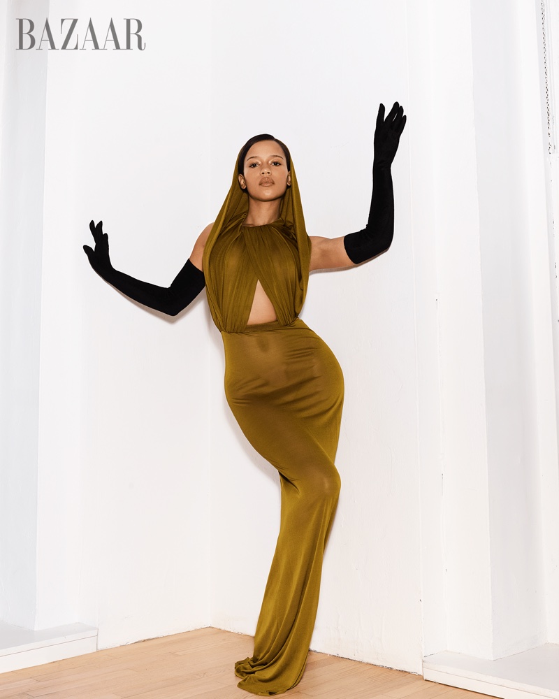 Fazendo pose, Taylor Russell usa vestido Saint Laurent com capuz e luvas Miscreants.