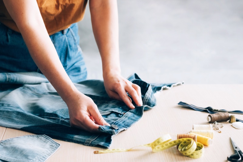 Woman Mending Jeans How to Make Clothes Last Longer