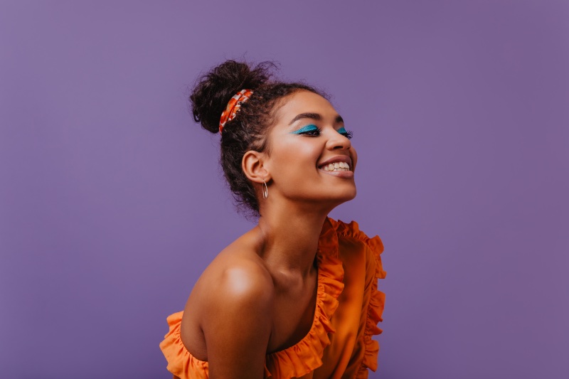 Black Woman Smiling Orange Top Summer Makeup