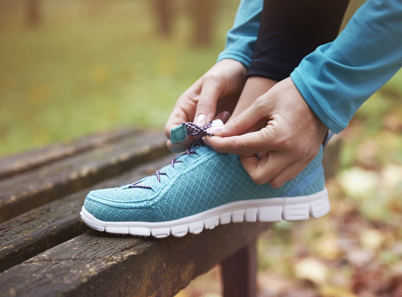 Woman Running Shoes Outside Park Bench