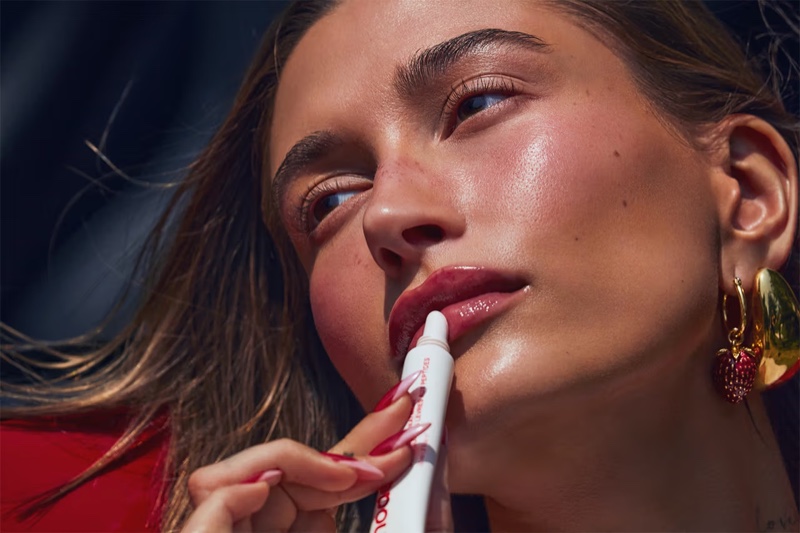 Closeup of Hailey Bieber's glossy pout, adorned with Rhode's Strawberry Glaze lip treatment.