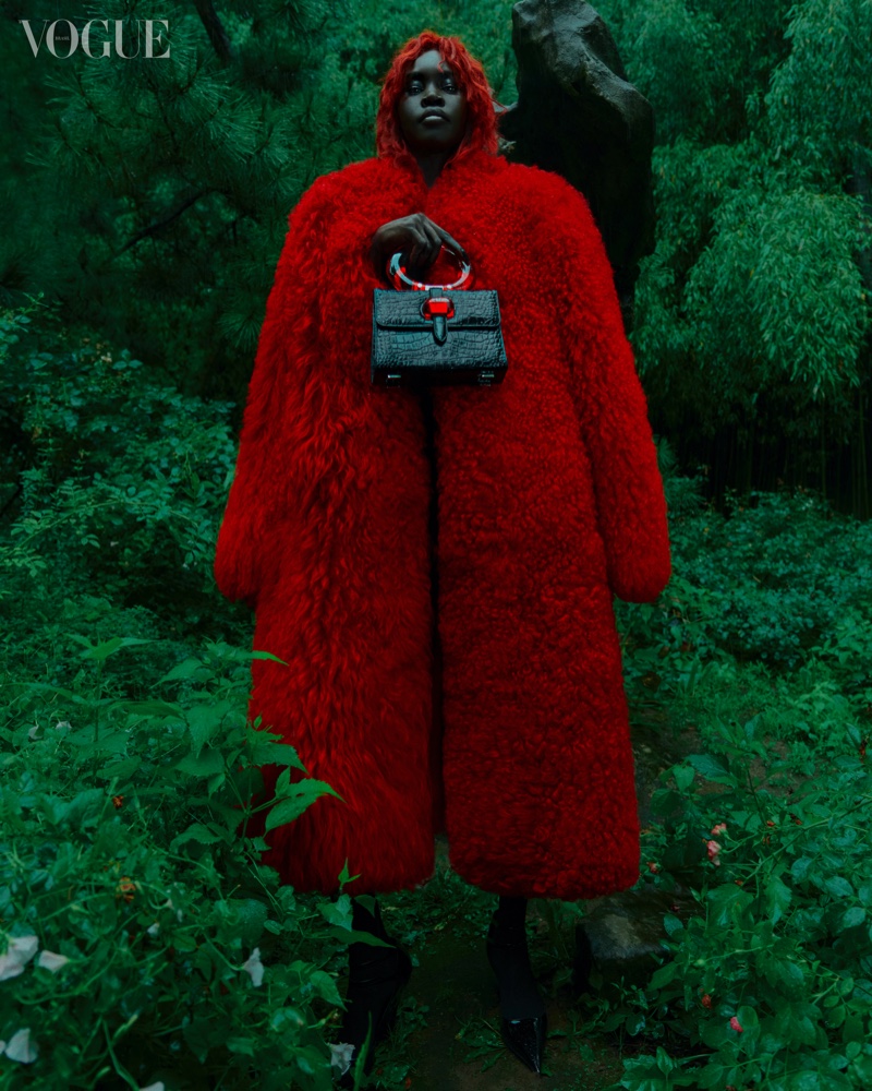 Alek Wek poses in red Ferragamo coat.