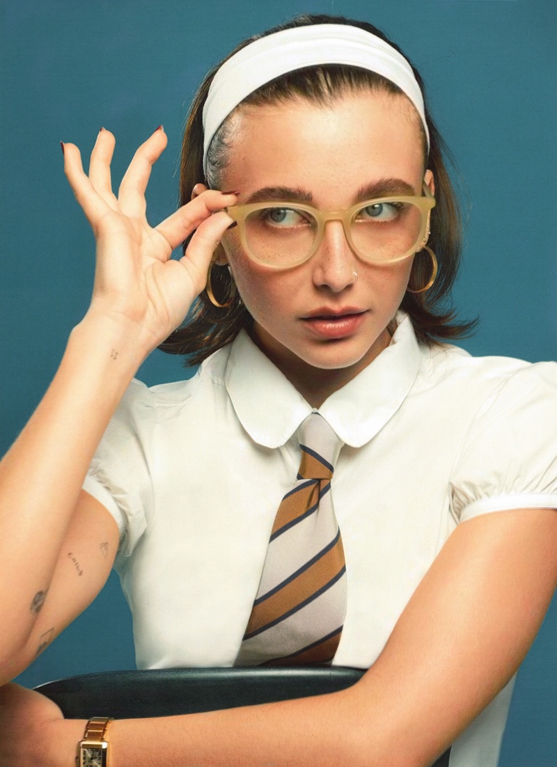 Emma Chamberlain adjusts her Warby Parker Durand glasses in Toasted Sesame as she strikes a scholarly pose.