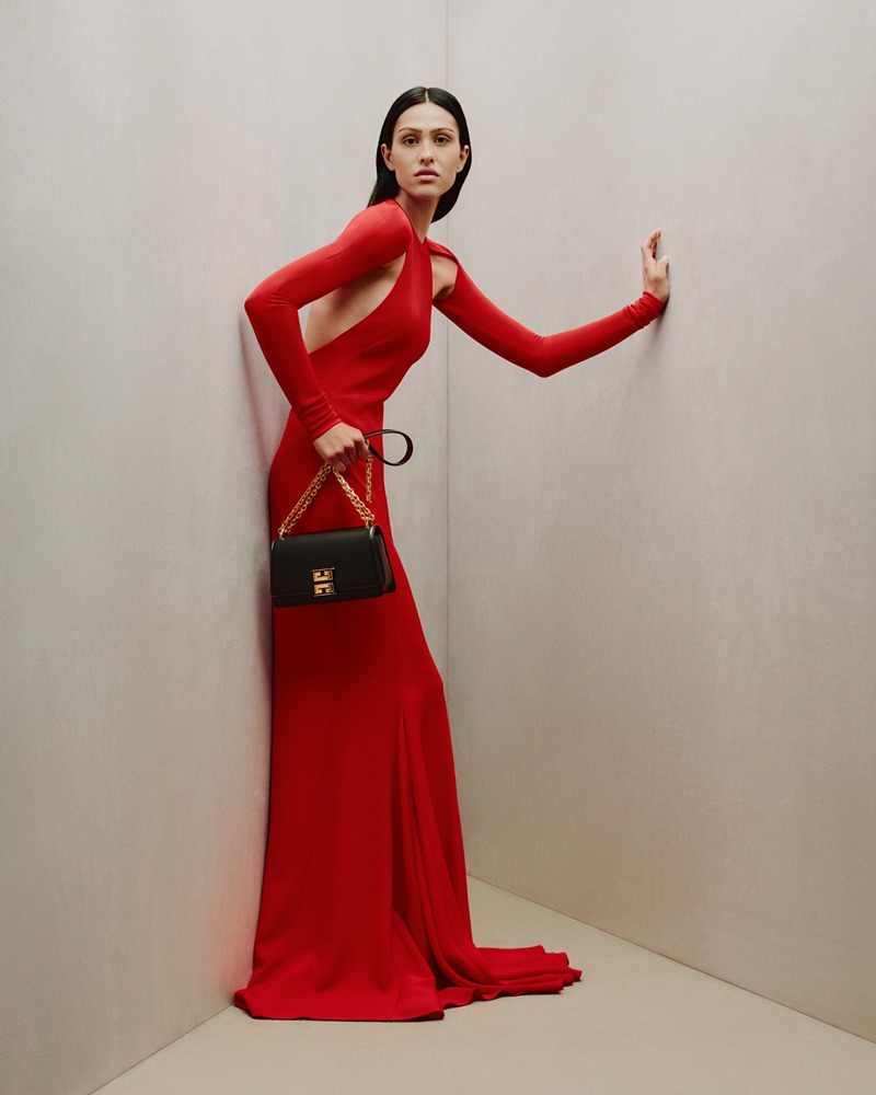 Elegance in Crimson: A striking pose in a bold red Givenchy gown, complemented by a classic black handbag, captures the essence of the 2023 holiday spirit.