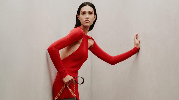 Elegance in Crimson: A striking pose in a bold red Givenchy gown, complemented by a classic black handbag, captures the essence of the 2023 holiday spirit.