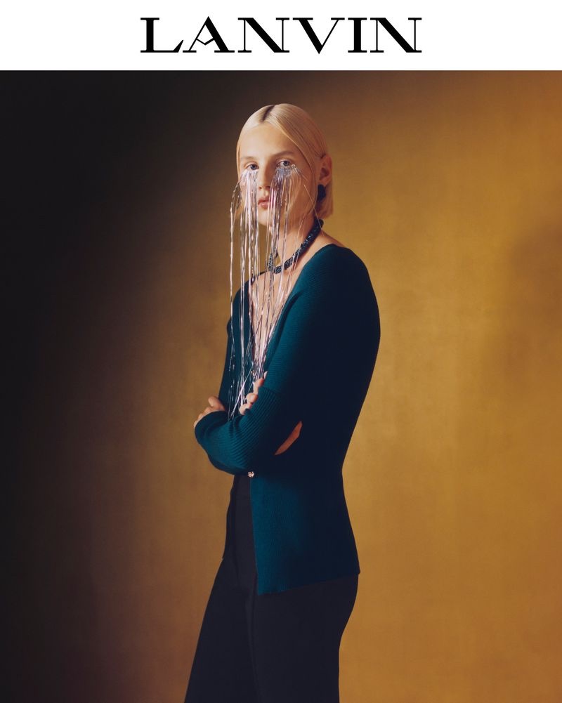 Elisa Nijman poses in a minimalist Lanvin ensemble, accentuated by a unique, crystal-like face accessory for the holiday 2023 collection.