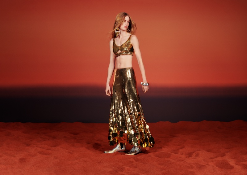 Rianne van Rompaey poses in a a gold sequin bralette and matching skirt for Rabanne H&M campaign.