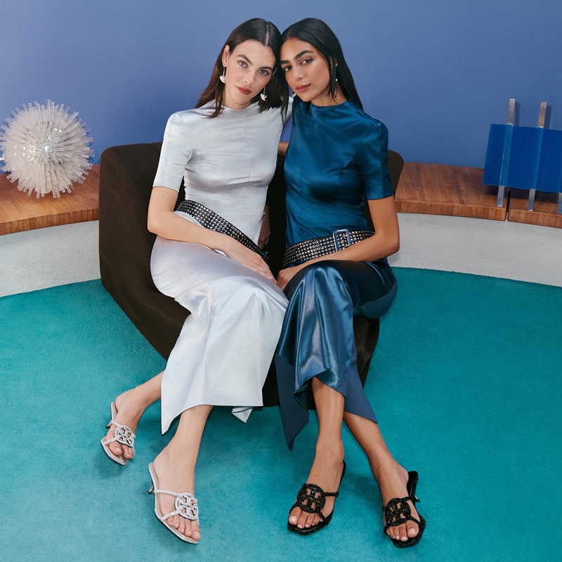 Tory Burch's holiday 2023 campaign features ivory and sapphire dresses accented with bejeweled belts.