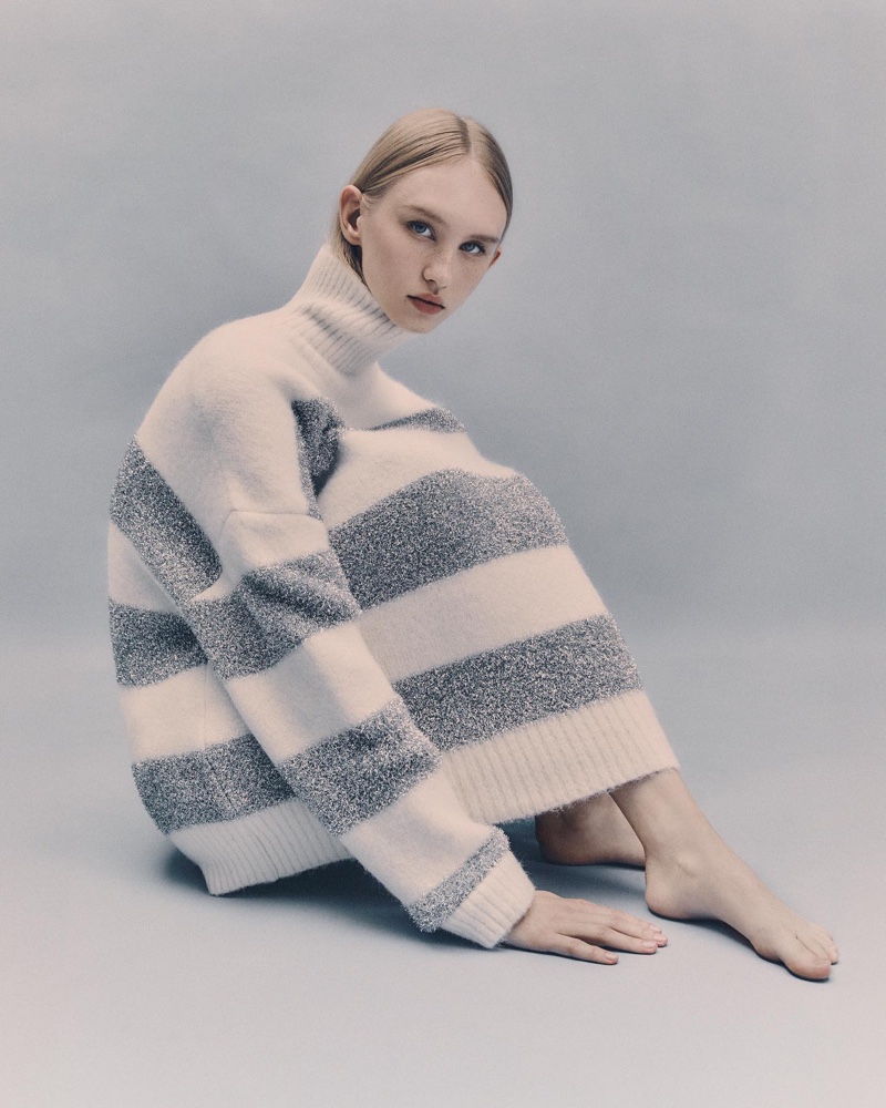 Lena Bystrova showcases an oversized striped sweater from AMI Paris's winter 2023 collection, embodying chic comfort.