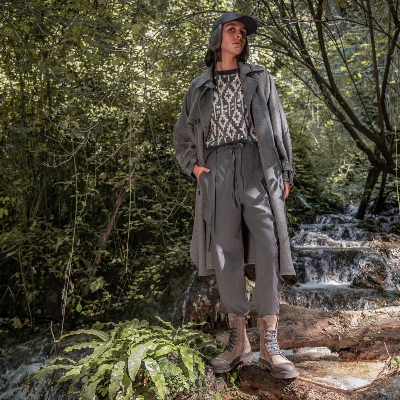 In a lush forest setting, model Amélie Zalaiti wears Brunello Cucinelli lace-up boots in earthy tones stand out as the season's must-have for adventurous elegance.