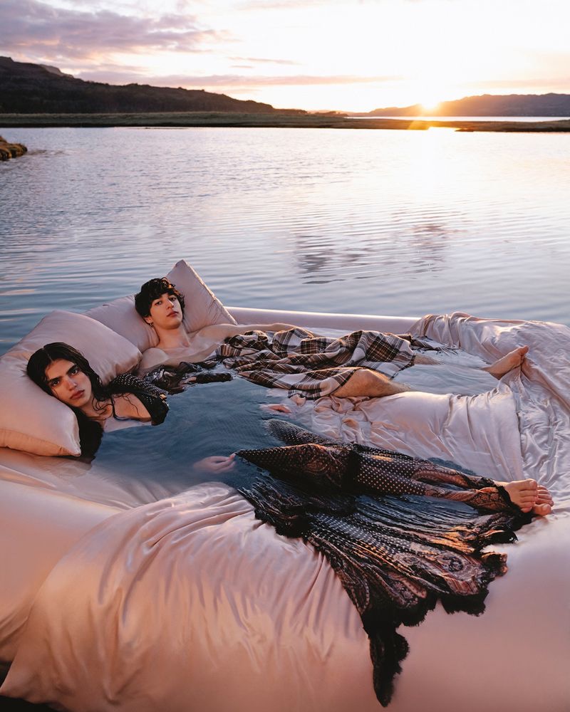 Sun Mizrahi and Nathaniël Ortiz draped in Etro's intricate fabrics find repose on an oversized bed for the fall-winter 2023 campaign.