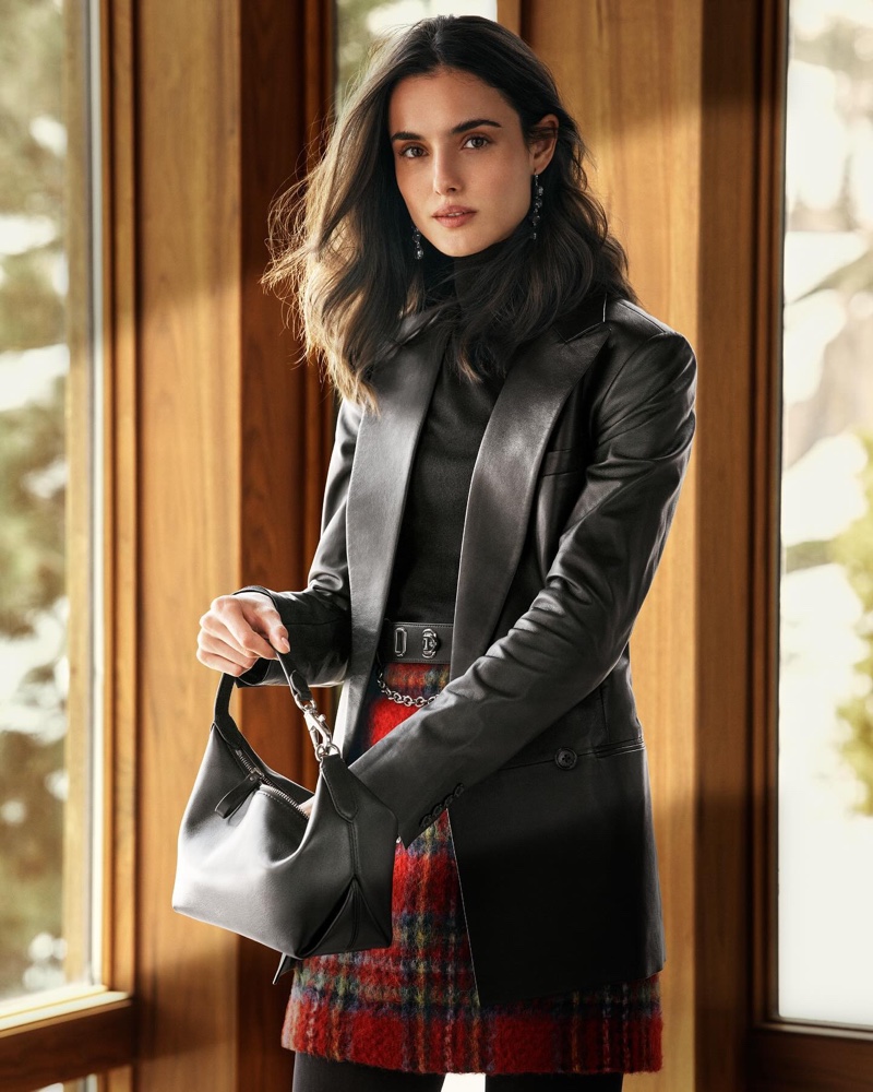 A sophisticated ensemble with a leather jacket and plaid skirt, accessorized with a sleek handbag — the epitome of Lauren Ralph Lauren's holiday chic.