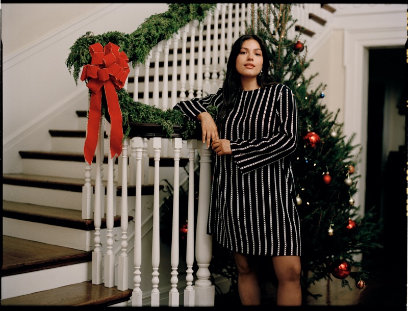 Elegance on the staircase with a touch of holiday spirit, as Vanessa Romo dons a Tommy Hilfiger striped dress, complementing the festive decor.