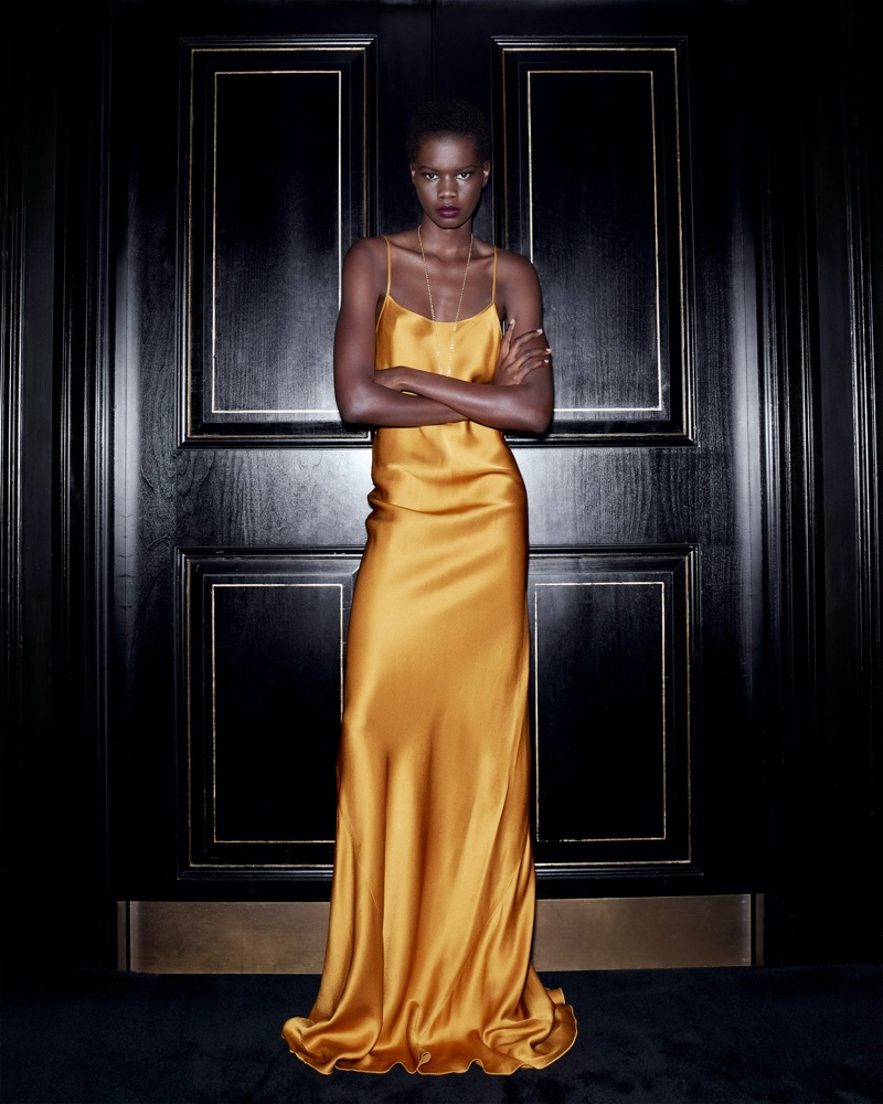 Captivating in a silky golden gown, Mary Ukech's commanding presence shines in the Victoria Beckham holiday 2023 campaign.