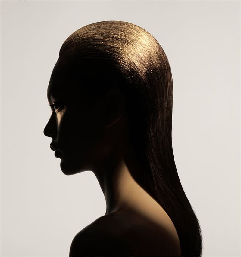 Profile view of a model with sleek, golden-tinged hair from the debut Zara Hair line.