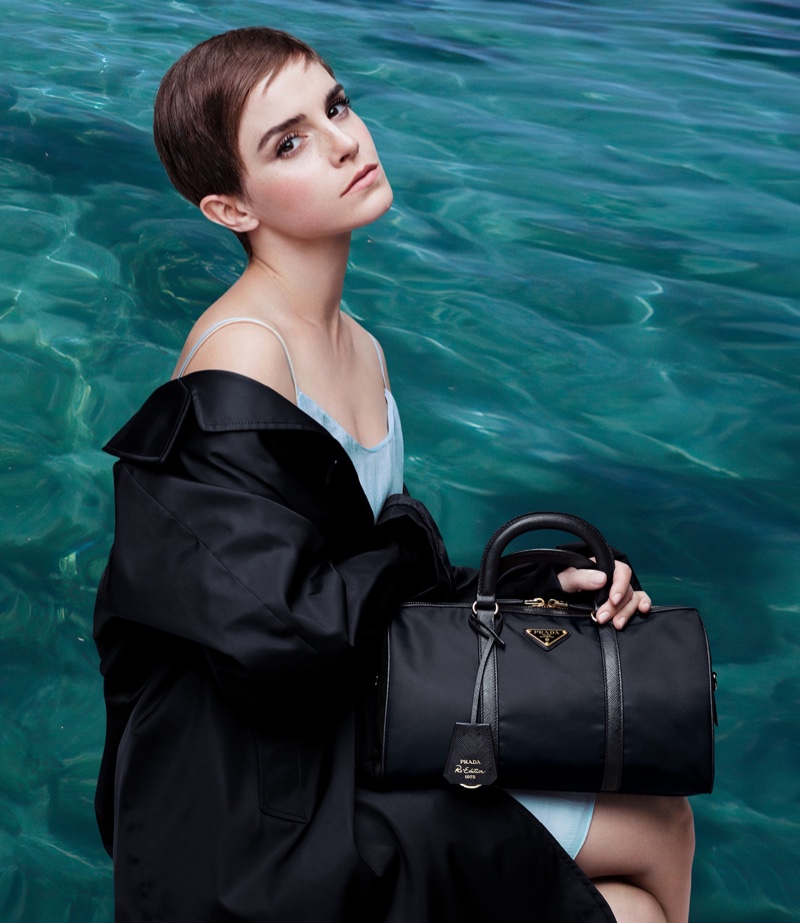 Clutching a Prada bag, Emma Watson showcases the Re-Nylon 2024 collection surrounded by ocean water.