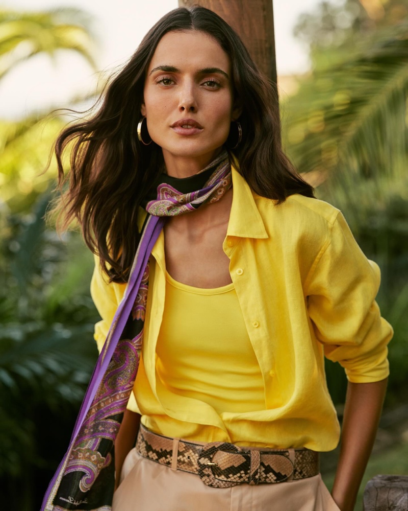 Vibrant yellow layers paired with a statement scarf and snake print belt featured in the Lauren Ralph Lauren resort 2024 collection.