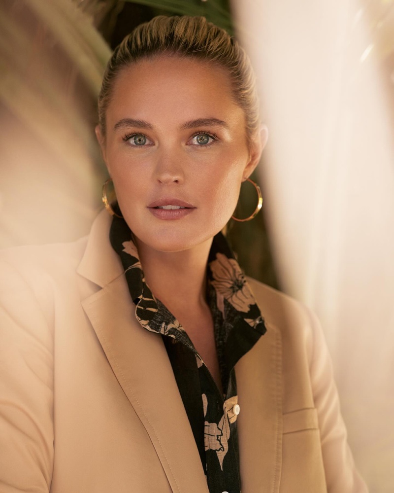 Posing for Lauren Ralph Lauren, Georgina Burke wears elegant beige blazer over a botanical blouse for resort 2024 season.