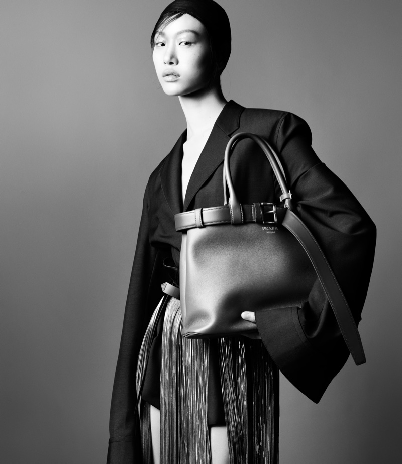 Prada showcases a bold silhouette for spring 2024, modeled by Sora Choi with a sleek bag complementing the structured blazer.