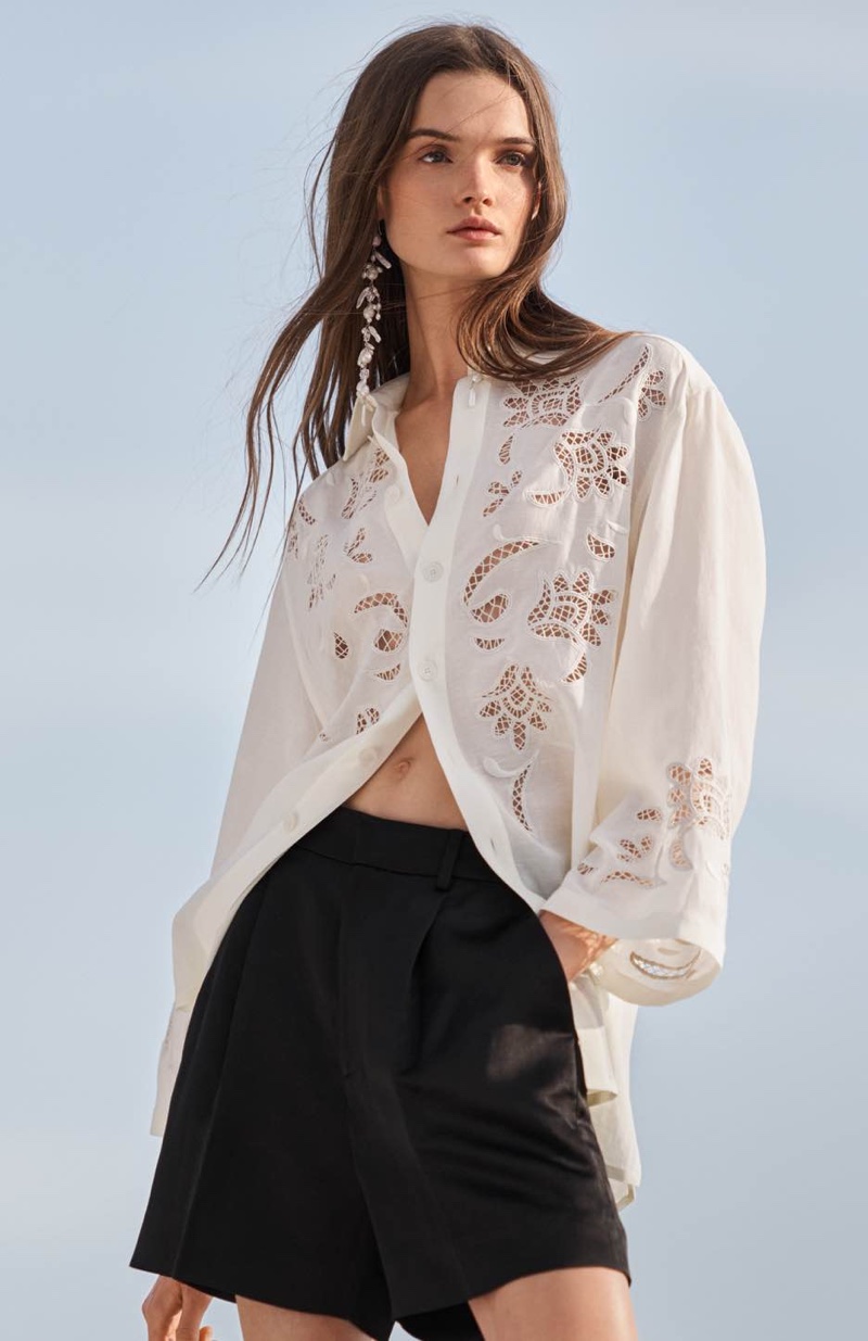 Elegance meets simplicity in Ralph Lauren's resort 2024 line featuring an embroidered white blouse paired with structured black shorts.