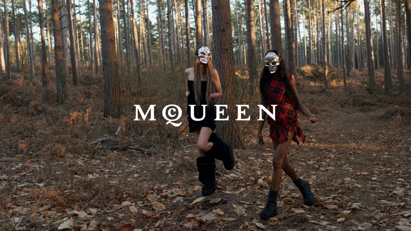 Frankie Rayder and Debra Shaw in skull masks stride through woods for the Alexander McQueen preview campaign by Seán McGirr.