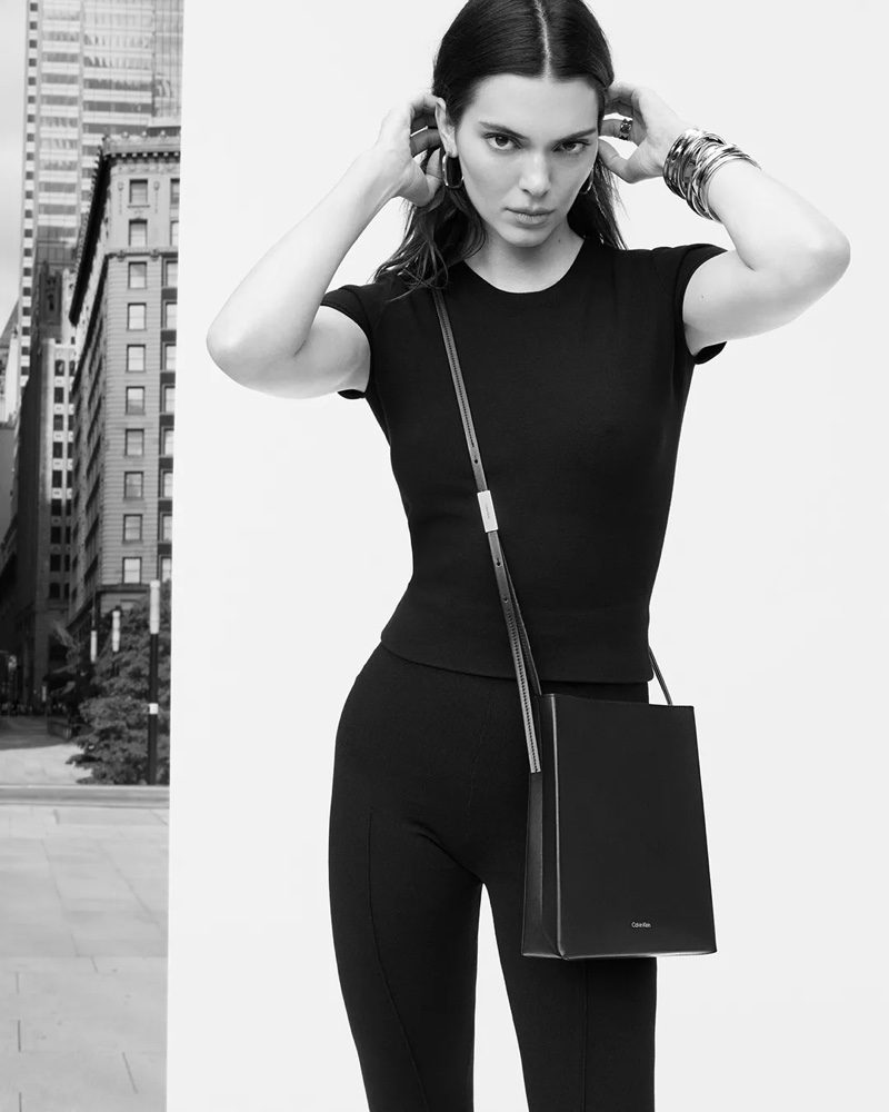 Kendall Jenner strikes a pose in a sleek, black ensemble, accentuated with a crossbody bag for Calvin Klein's spring 2024 advertisement.