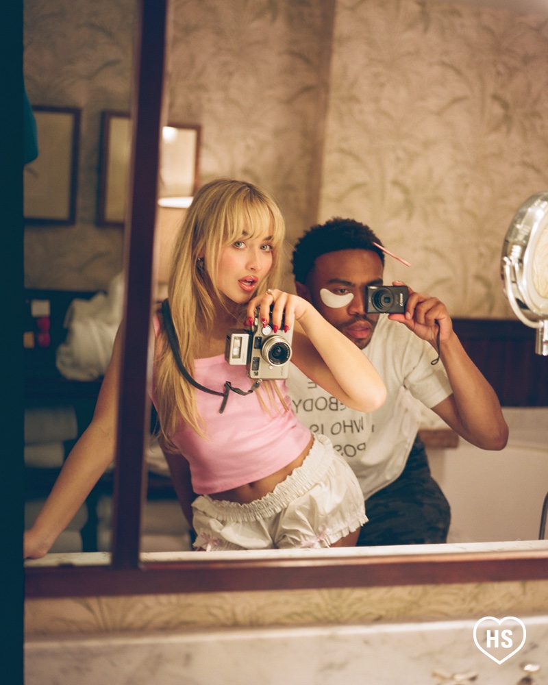 Capturing a candid moment, Sabrina Carpenter snaps a photo in the mirror, accompanied by her friend Kevin Abstract.