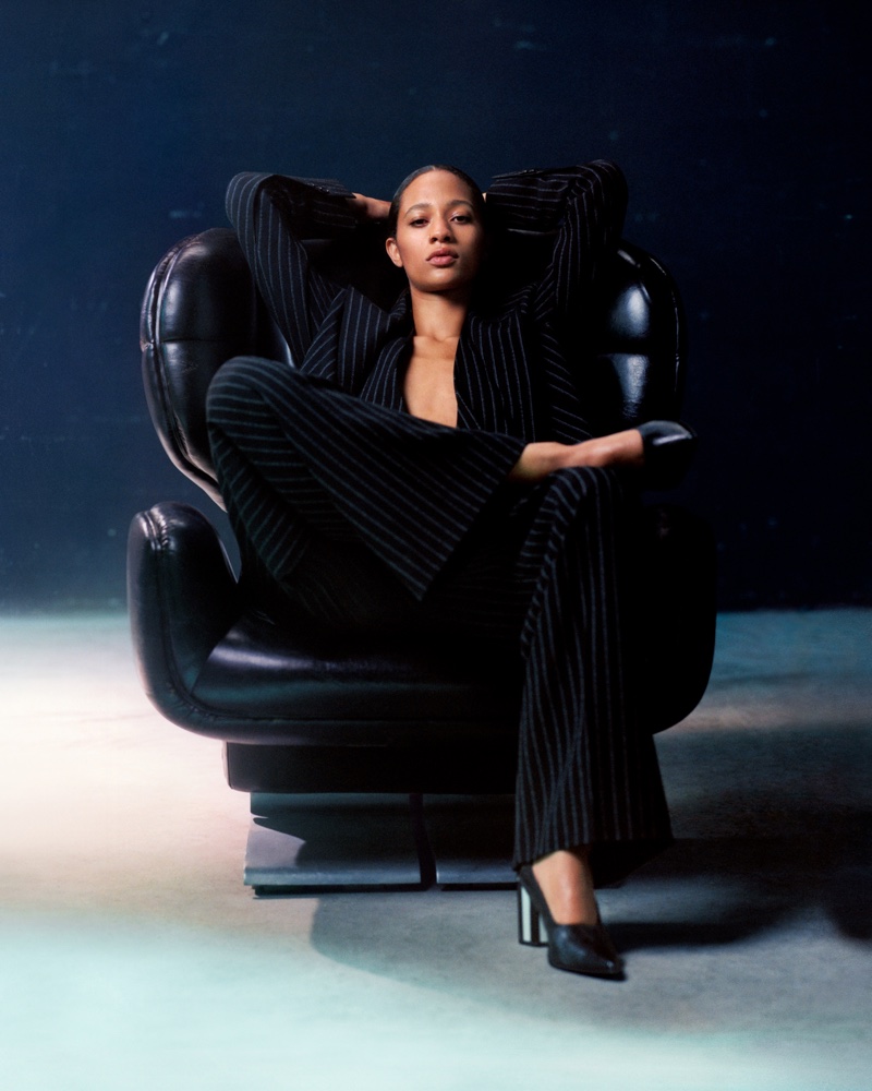 Selena Forrest strikes a pose in a pinstriped pantsuit for AMI Paris' spring 2024 campaign.