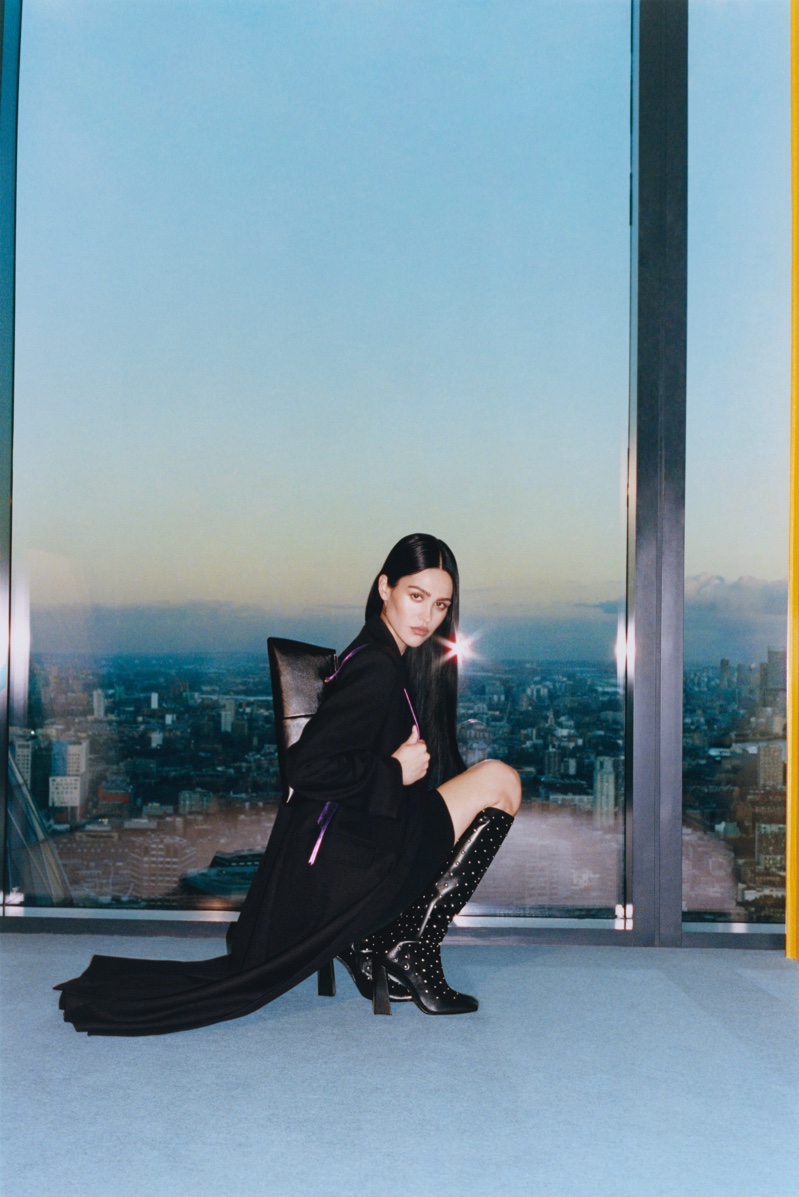 In the Schutz winter 2024 ad, Amelia Gray poses with knee-high boots against a city backdrop.