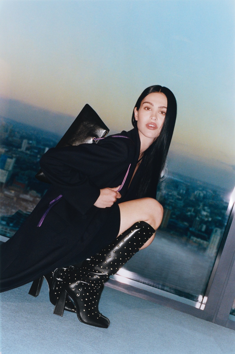 The Schutz winter 2024 advertisement features Amelia Gray in a striking black ensemble with studded boots.