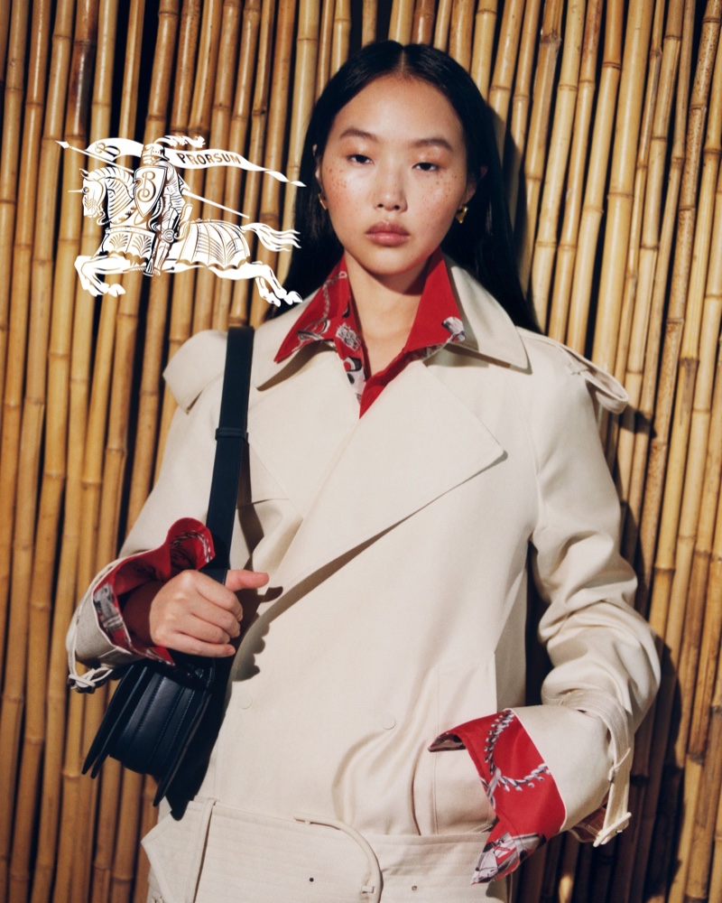 Peng Chang in a beige trench coat and red accented accessories for Burberry's summer 2024 advertisement.