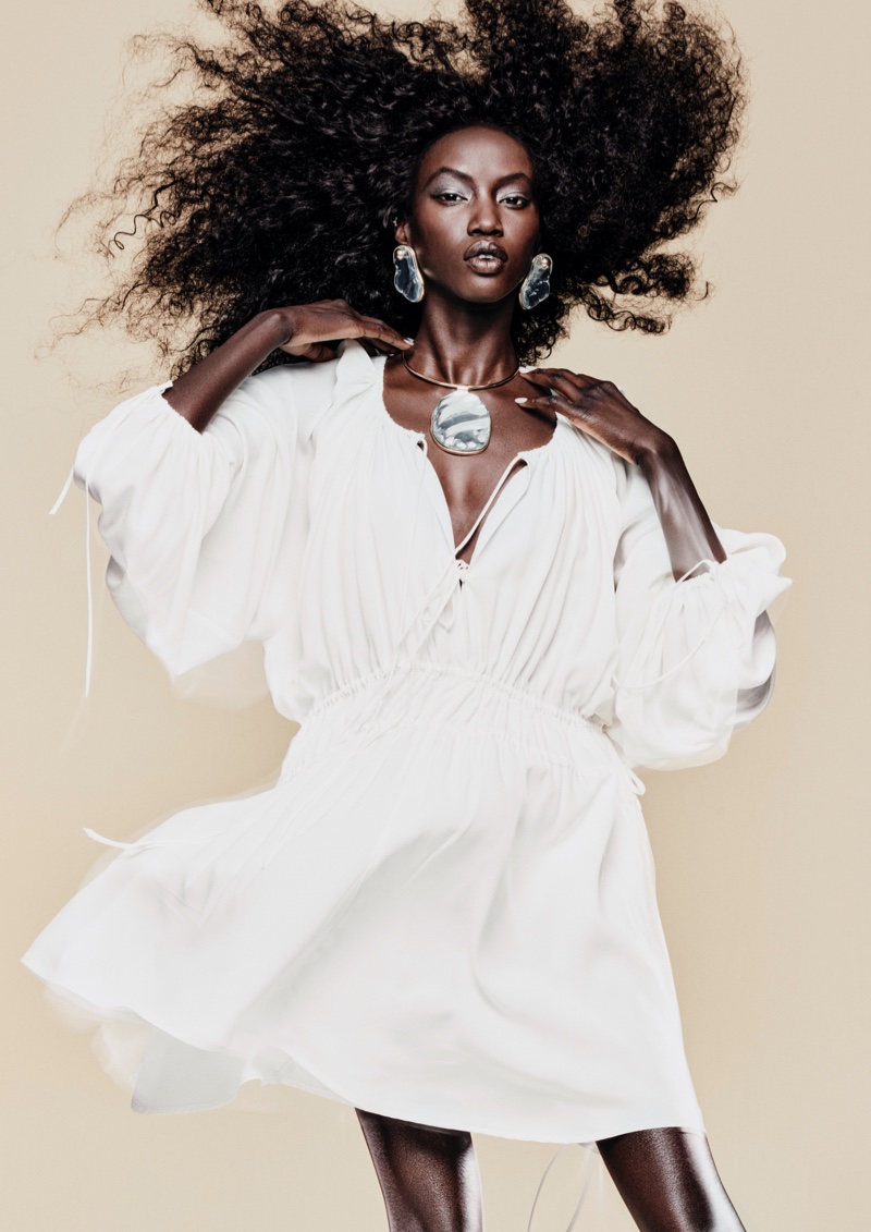 Anok Yai showcases a white gathered dress, adorned with unique jewelry for H&M's spring 2024 campaign.