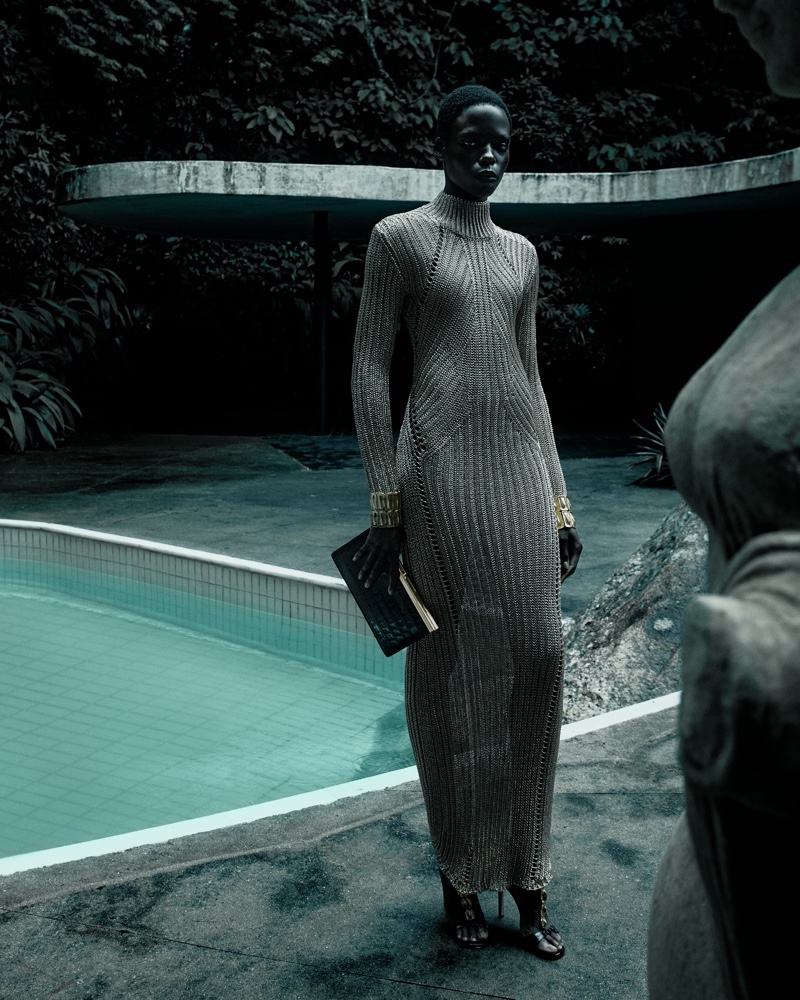 Agel Akol poses in a metallic knit dress beside a pool for the Tom Ford summer 2024 campaign.