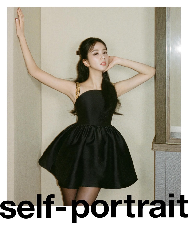 Jisoo strikes a pose in Self-Portrait's pre-fall 2024 attire, highlighting a sleek black dress with golden accents.